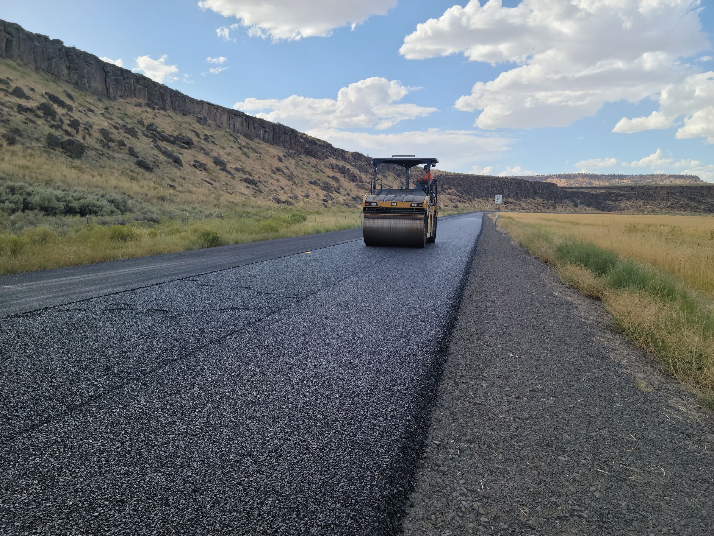 Crew placing fresh asphalt on a prepared road surface